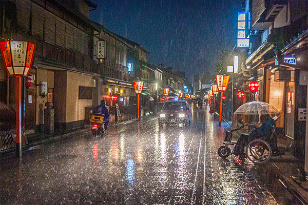 Dramatic photograph of a rainy, nighttime streetscape in Asia.
