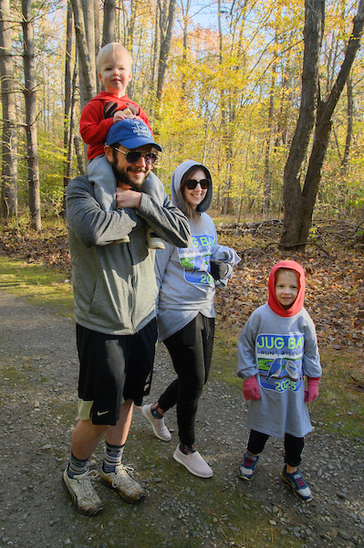 Family walks along a wooded trail during a community nature hike.