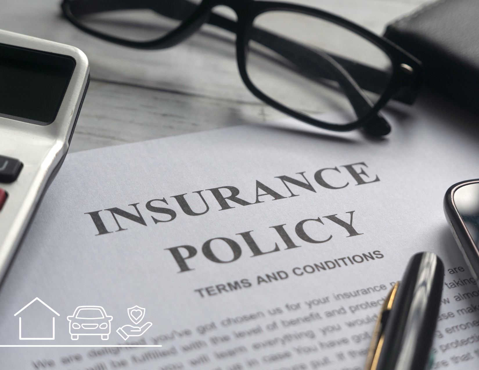 An "INSURANCE POLICY" document laid on a desk alongside black-framed reading glasses, a calculator, and a pen.