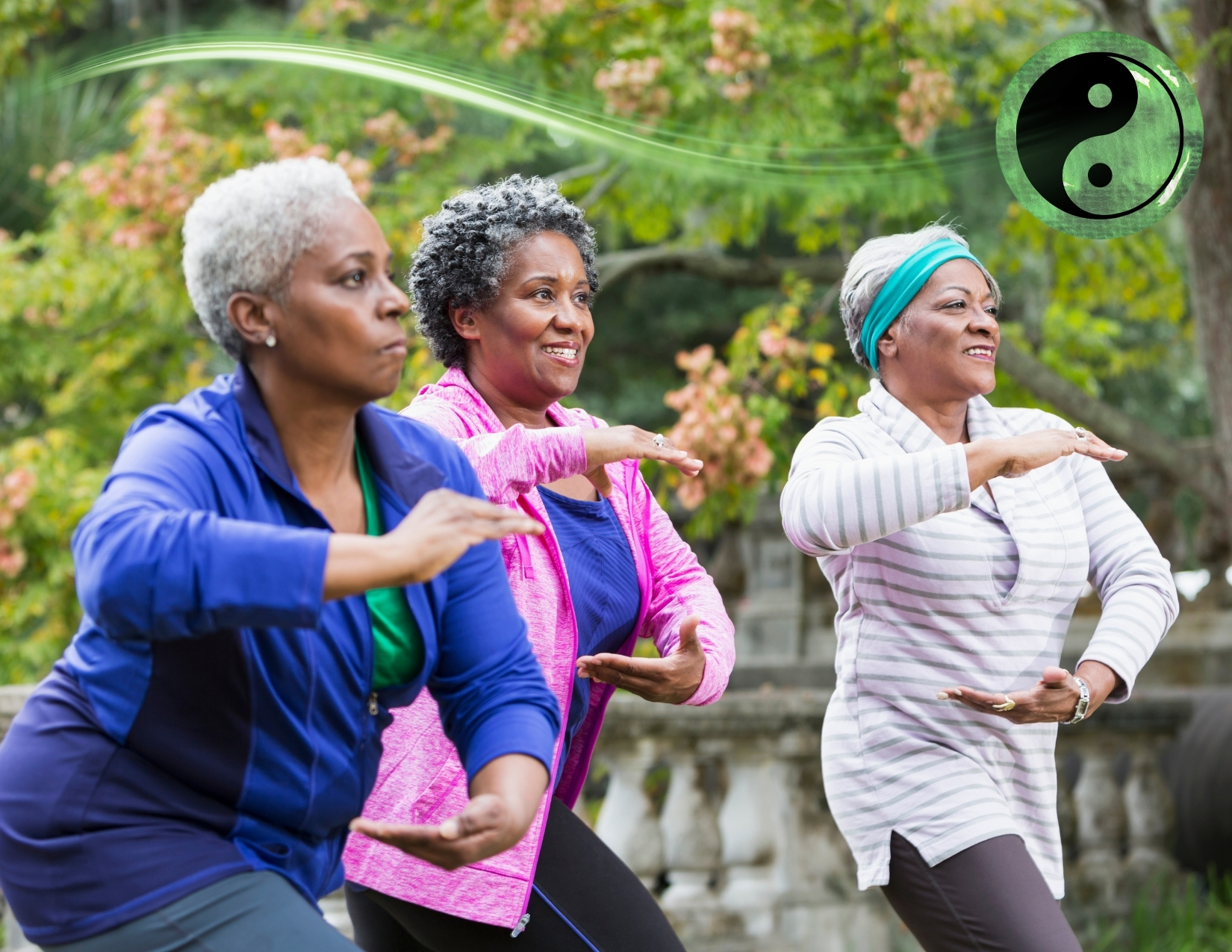 Three older women performing graceful Tai Chi movements together in an outdoor park setting with a yin-yang symbol nearby.